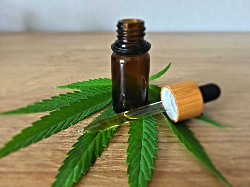 Why you should source your CBD from a dispensary - a tincture bottle on a cannabis leaf.