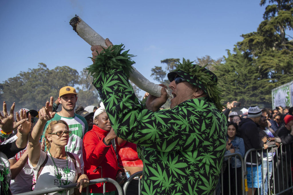 Hippie Hill in San Francisco - a man in a weed leaf outfit smokes a giant joint at 4/20 on Hippie Hill